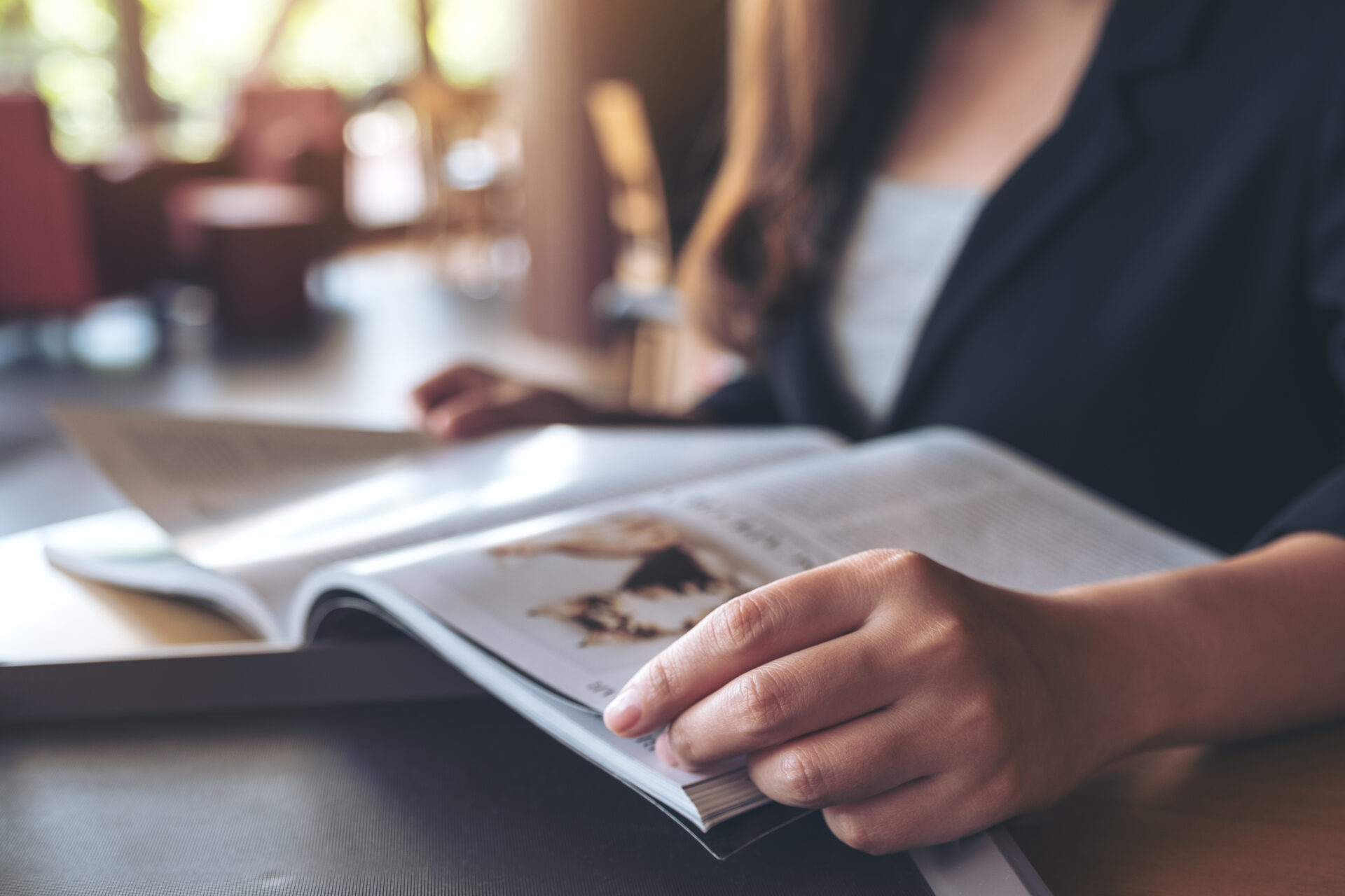 Closeup image of a business woman reading a book in modern cafe