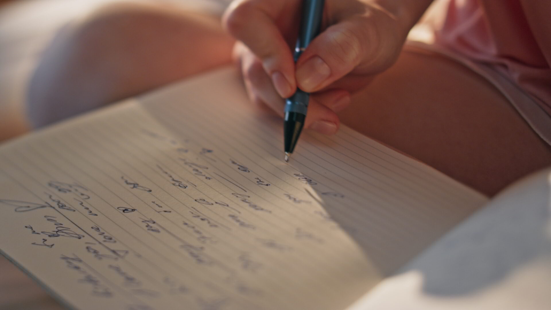 Closeup hand writing diary in golden sunlight. Unknown romantic girl make notes in morning pajamas. Inspired teenager writer noting poems enjoying weekend at home. Personal notebook planning concept.