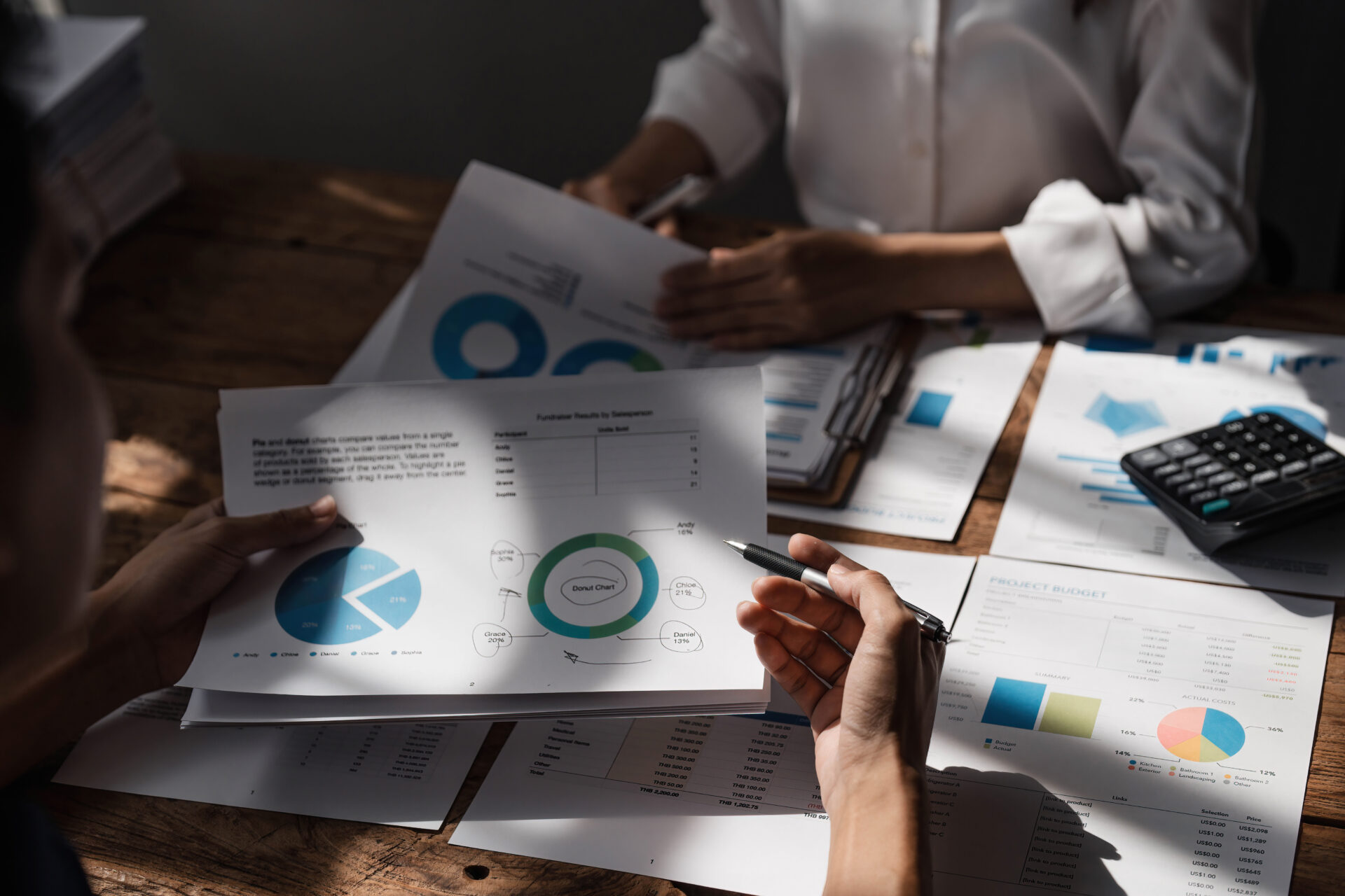 Business People Meeting using laptop computer,calculator,notebook,stock market chart paper for analysis Plans to improve quality next month. Conference Discussion Corporate Concept....