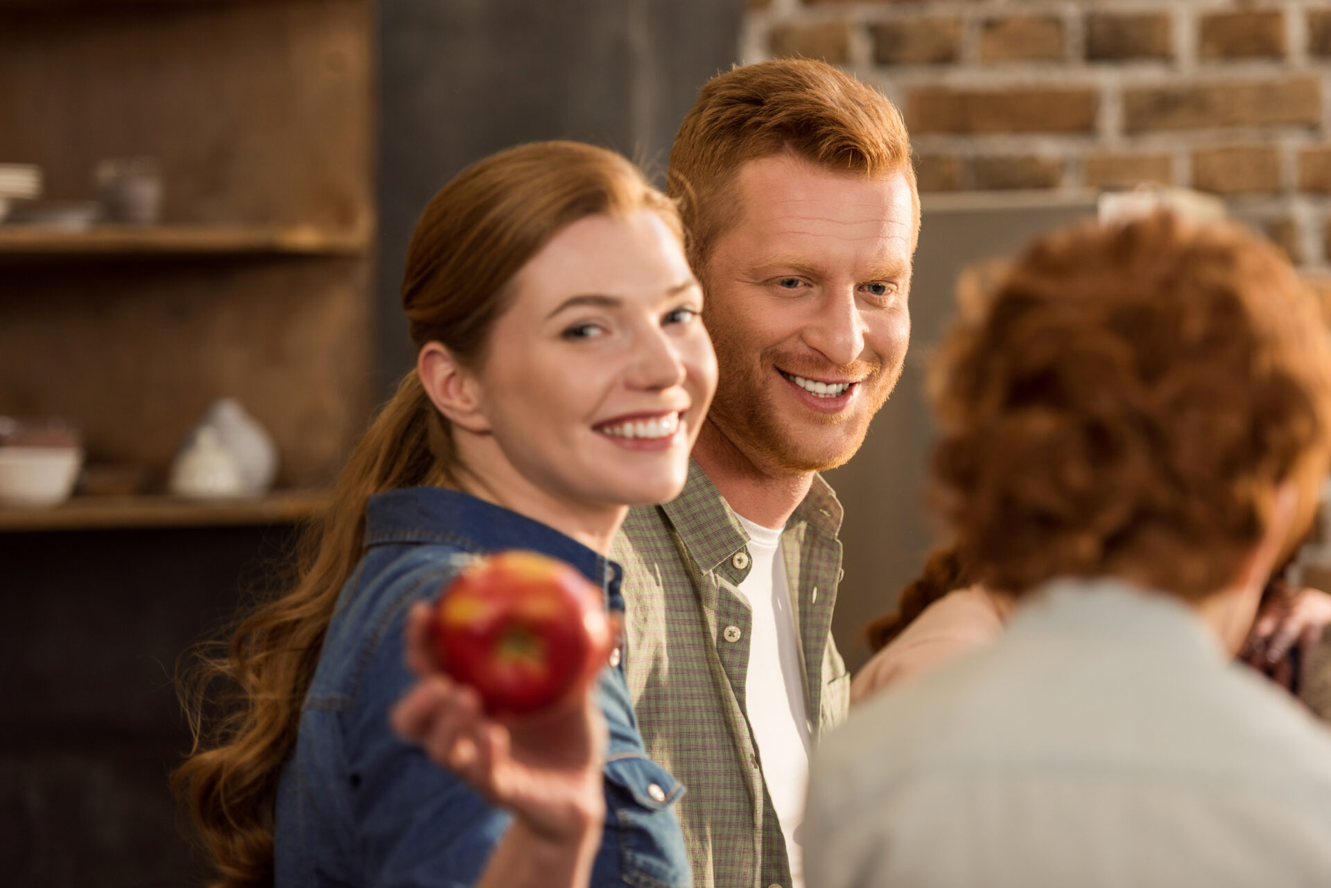 selective focus of smiling woman showing fresh apple in hand